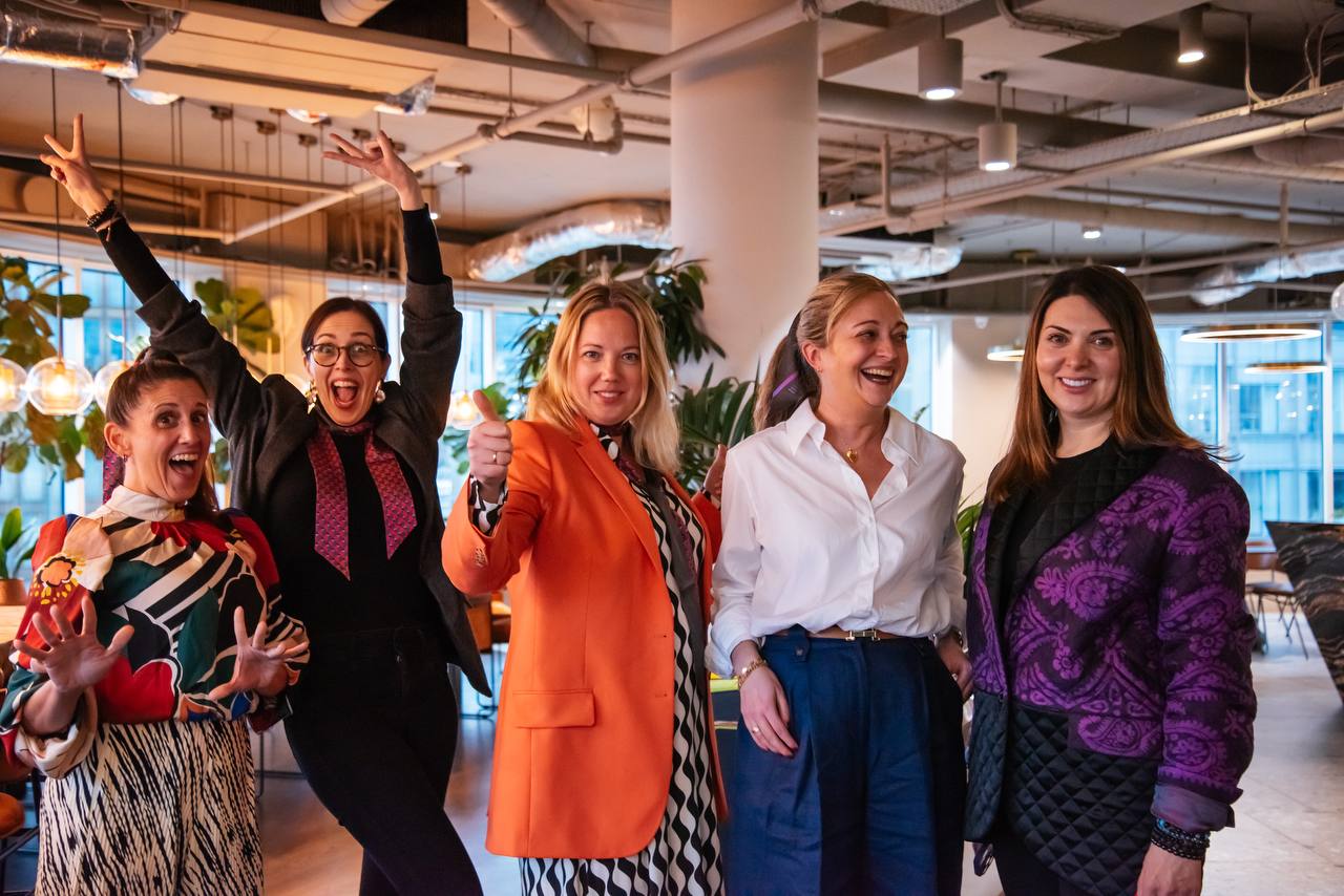 Five women celebrating together at an IWA community gathering